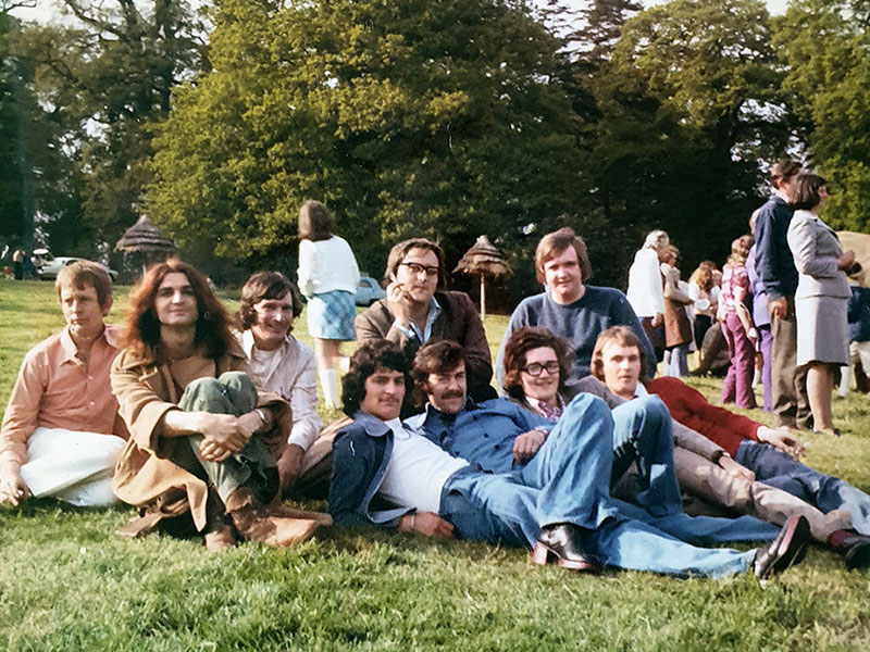 Group of men sitting together on the grass