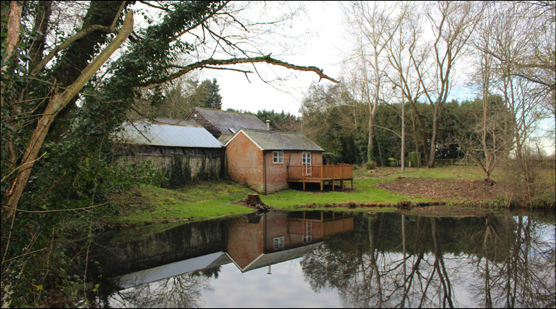 Some farm buildings and a lake 