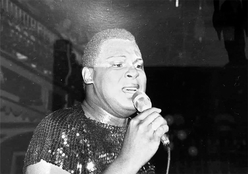 Close up of Sylvester singing into a microphone