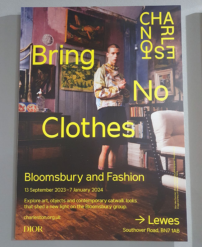 Poster for the Bring No Clothes: Bloomsbury and Fashion exhibition, featuring someone standing in Duncan Grant's studio wearing clothes inspired by Bloomsbury. 