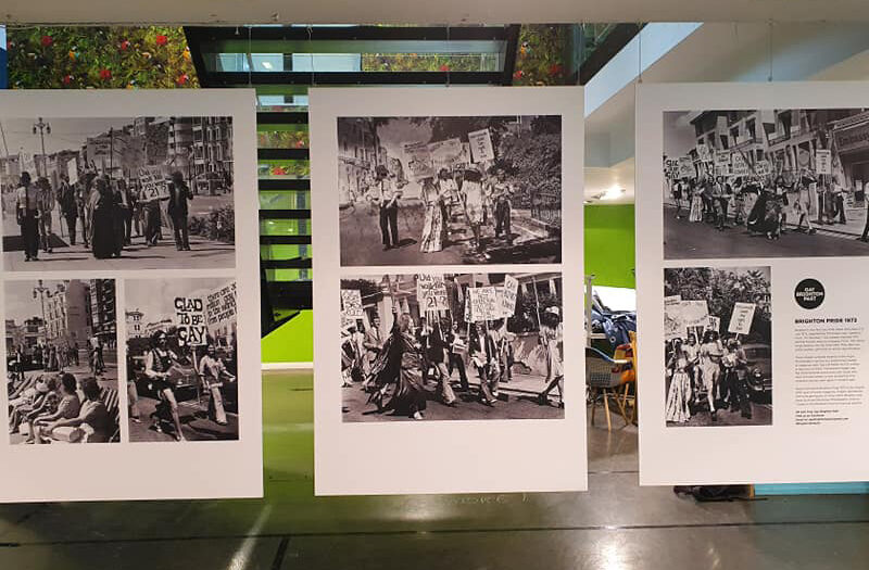 Three panels of black and white photos hanging in a gallery space