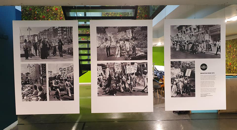 Three panels of black and white photos hanging in a gallery space