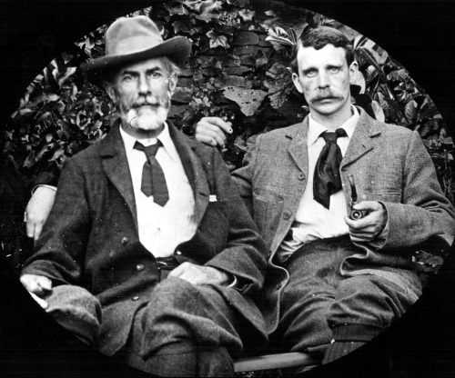 Black and white photo of two white men sitting side by side