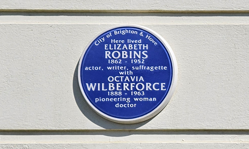 Blue plaque on a cream wall with the words: Here lived Elizabeth Robins 1862–1952: actor, writer, suffragette; with Octavia Wilberforce 1888–1963: pioneering woman doctor